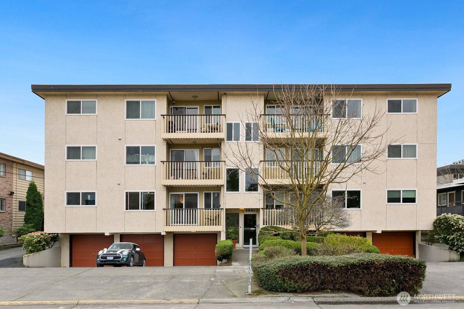 2031 Northwest 59th Street, Unit 101 Seattle, WA 98107 - Photo 2 of 22 a front view of a building with a garden