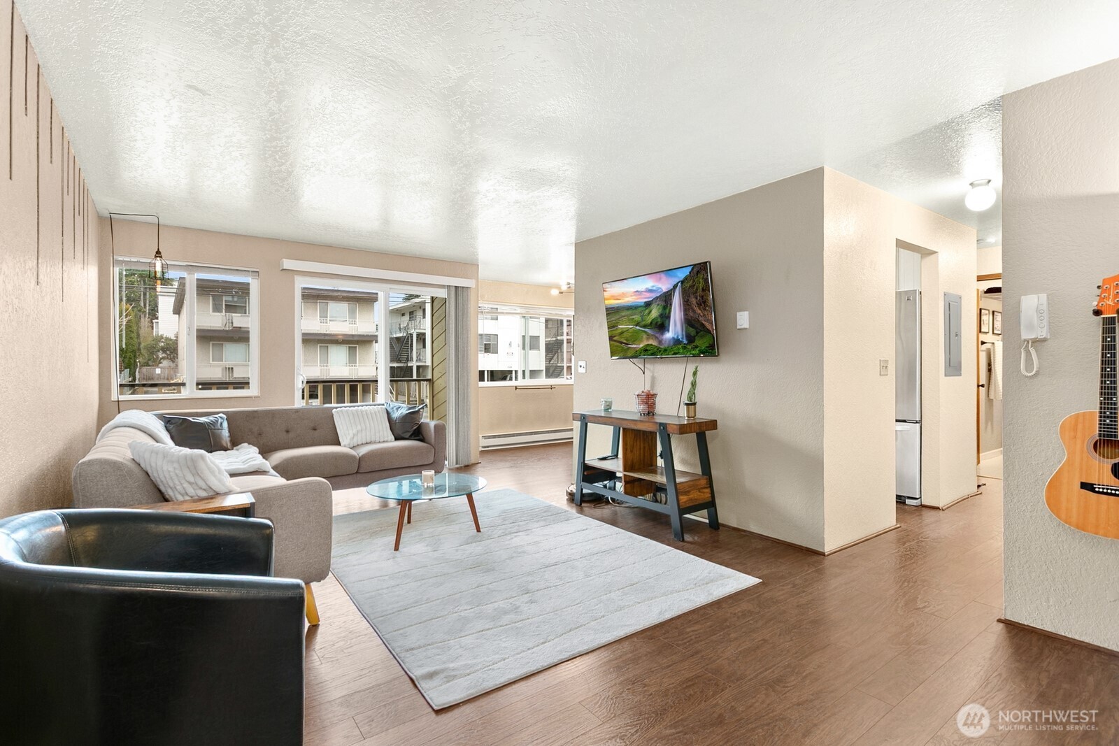 2031 Northwest 59th Street, Unit 101 Seattle, WA 98107 - Photo 5 of 22 a living room with furniture wooden floor and a flat screen tv