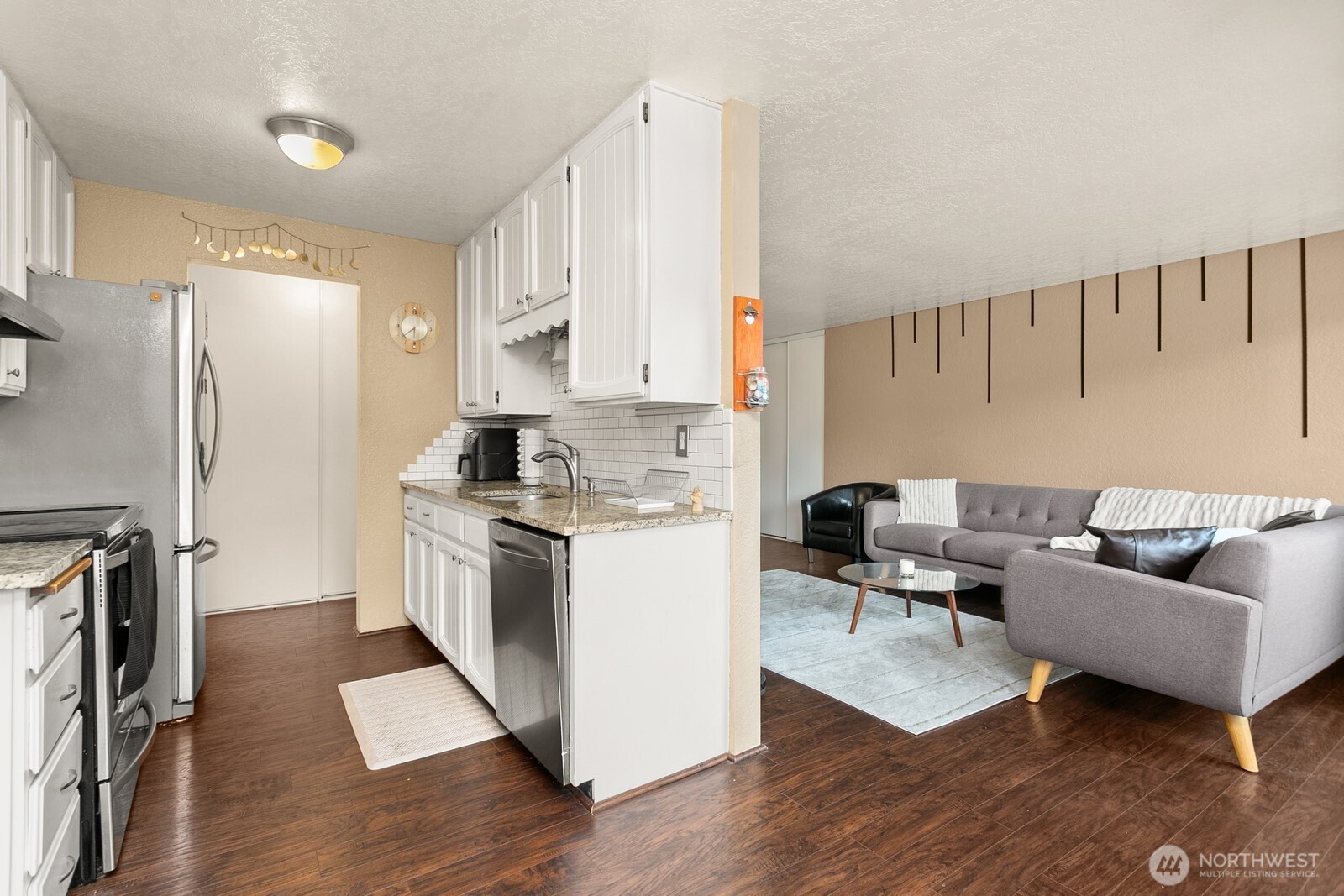 2031 Northwest 59th Street, Unit 101 Seattle, WA 98107 - Photo 10 of 22 a kitchen with a refrigerator and a stove top oven