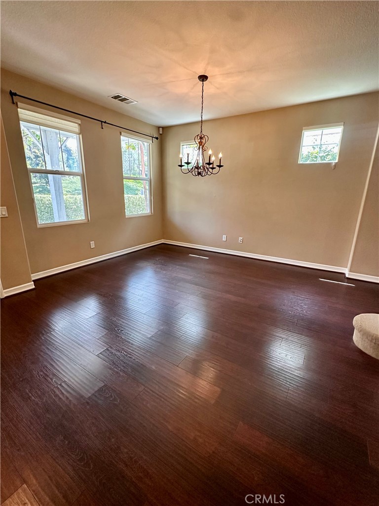 51 Ethereal Ladera Ranch, CA 92694 - Photo 5 of 14 an empty room with wooden floor chandelier and windows
