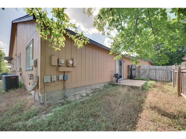a backyard of a house with table and chairs