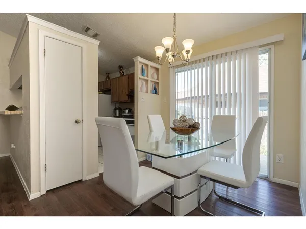 a dining room with furniture a chandelier and wooden floor