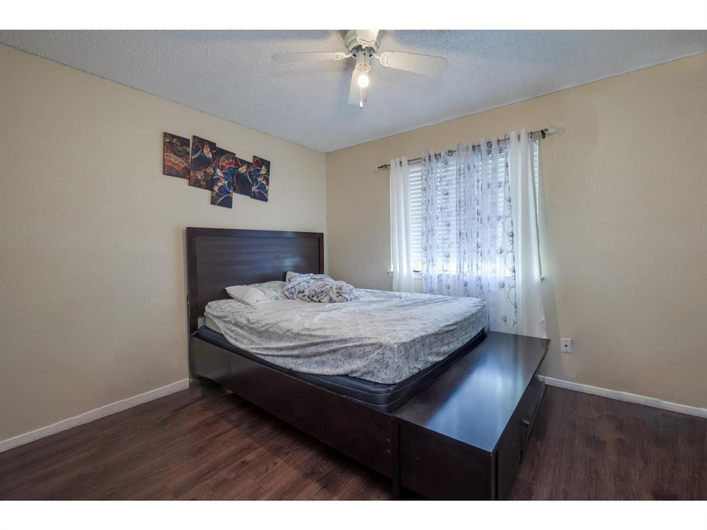 11919 Sunhillow Bend, Unit B Austin, TX 78758 - Photo 8 of 12 a bedroom with a bed and a chandelier