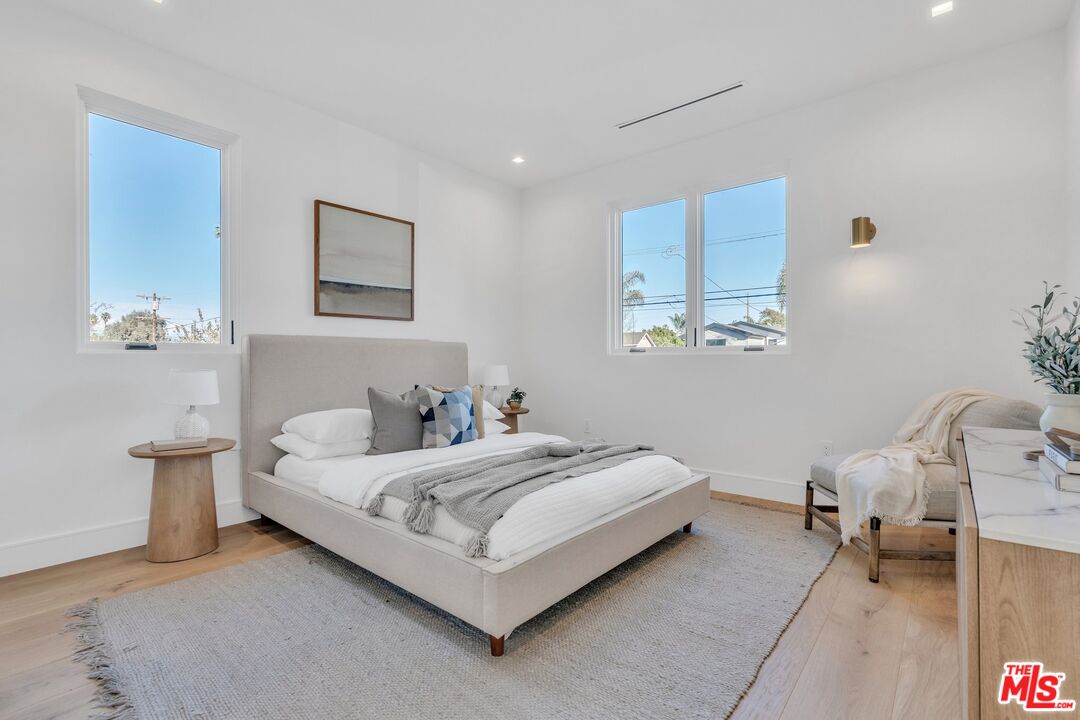 1071 Marco Place Venice, CA 90291 - Photo 16 of 39 a white bed sitting in a bedroom next to a lamp and a chandelier