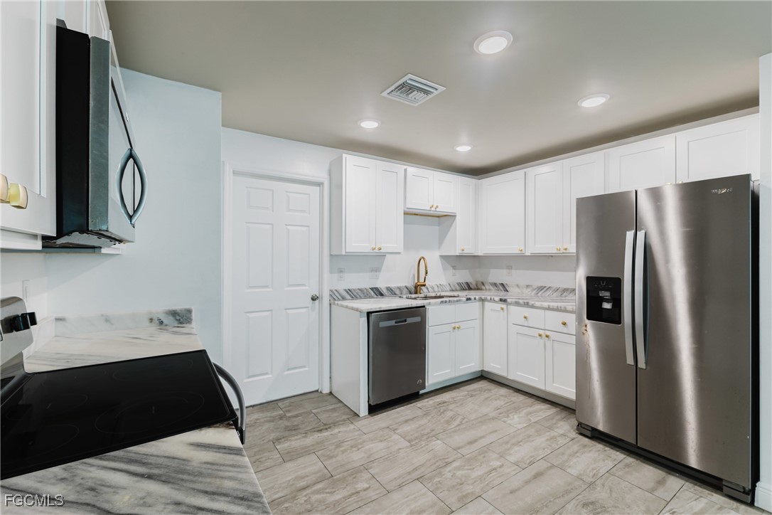 2405 Maple Avenue Fort Myers, FL 33901 - Photo 19 of 27 a kitchen with stainless steel appliances granite countertop a refrigerator and a stove top oven