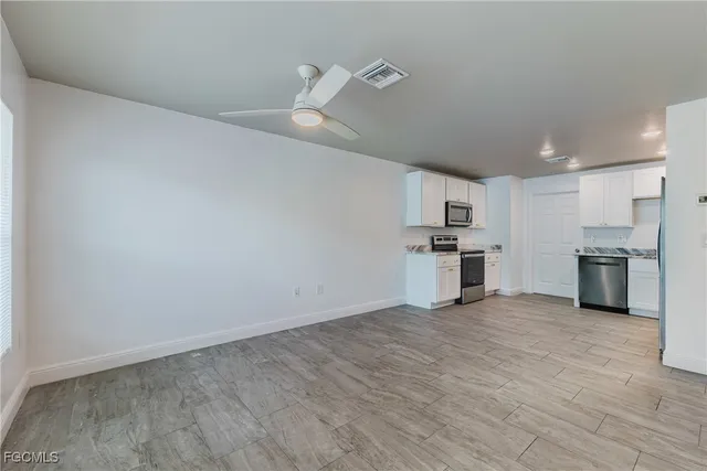 a view of a kitchen with a sink and stainless steel appliances