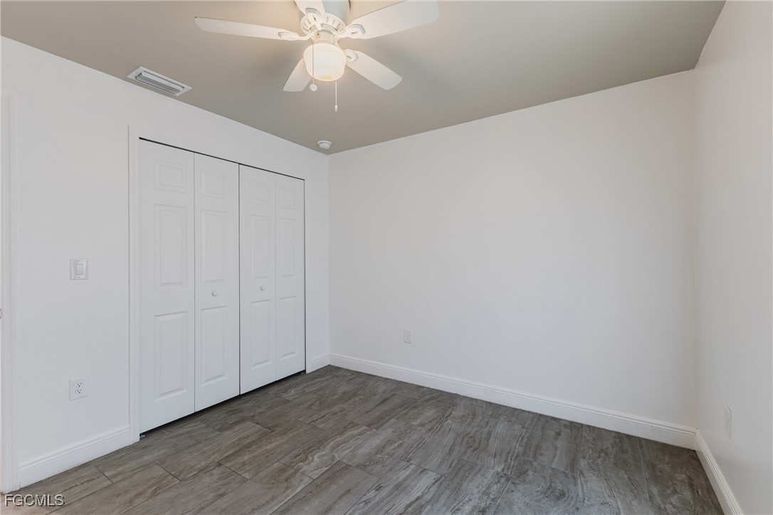 2405 Maple Avenue Fort Myers, FL 33901 - Photo 9 of 27 an empty room with wooden floor and fan