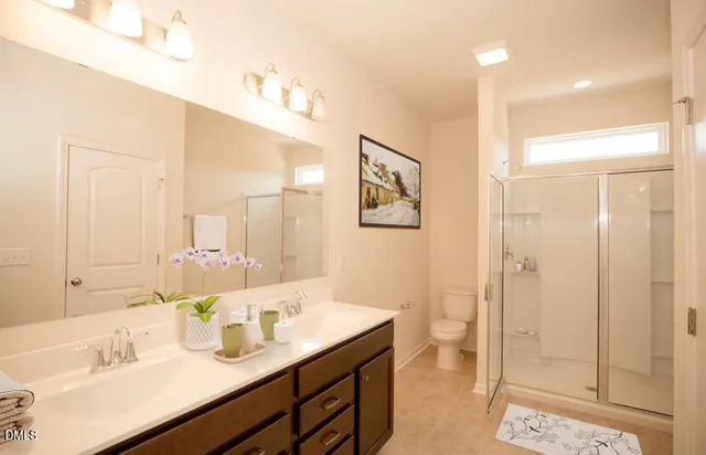 a bathroom with a double vanity sink mirror and shower