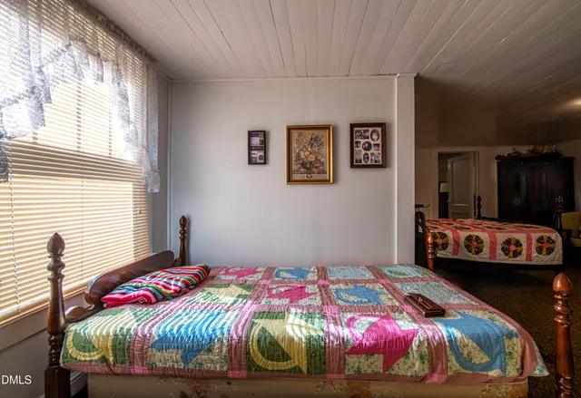 a bedroom with a bed and a painting on the wall