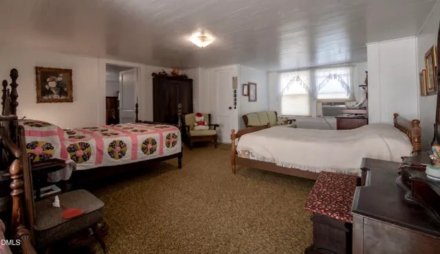 a bedroom with a bed and dresser with mirror