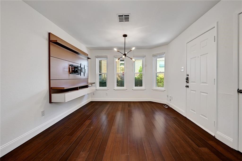 2104 Cullen Avenue, Unit 4117 Austin, TX 78757 - Photo 18 of 36 a view of an empty room with window and wooden floor