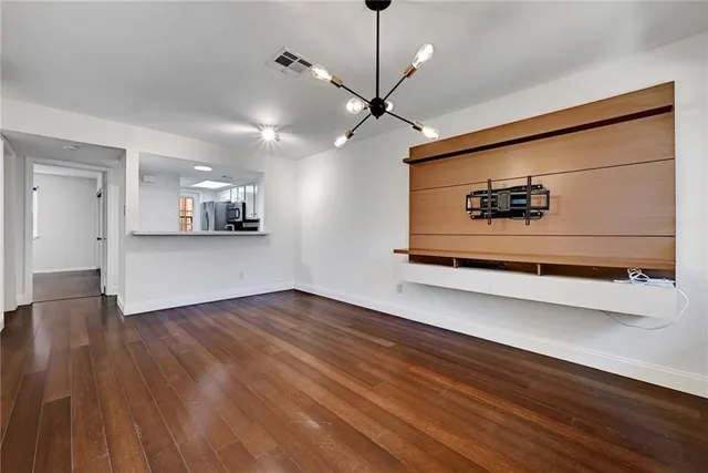 a view of a room with wooden floor and a ceiling fan