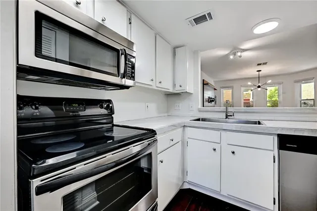 a kitchen with stainless steel appliances a stove microwave and cabinets