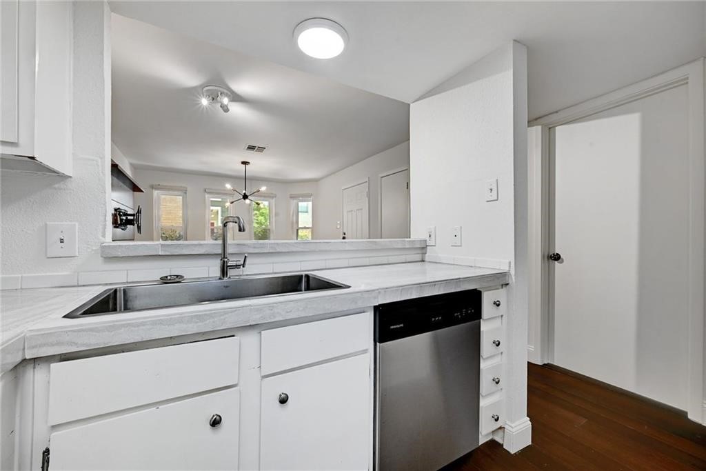 2104 Cullen Avenue, Unit 4117 Austin, TX 78757 - Photo 23 of 36 a kitchen with a sink dishwasher and cabinets with wooden floor