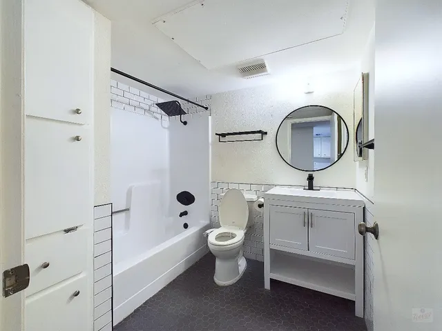 a bathroom with a toilet sink and mirror