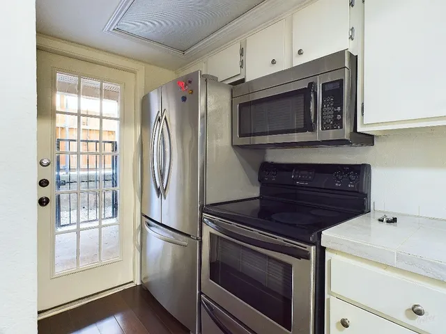 a kitchen with granite countertop cabinets stainless steel appliances and wooden floor