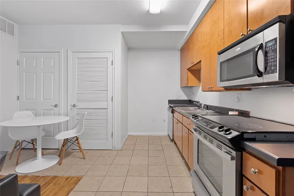 a kitchen with stainless steel appliances granite countertop a stove a sink and a microwave