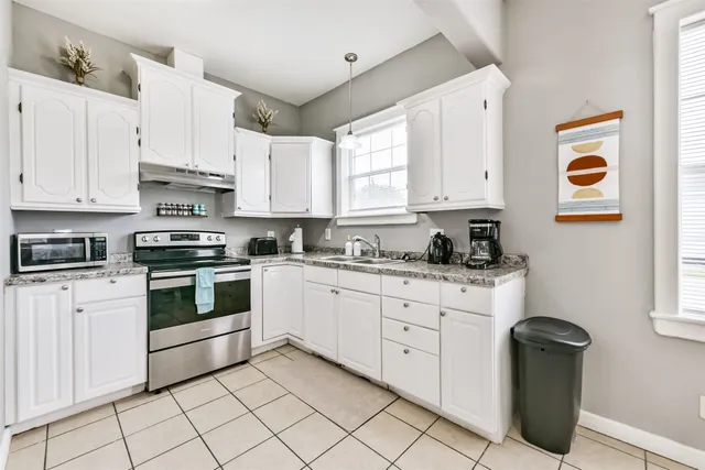 a kitchen with granite countertop white cabinets and white appliances