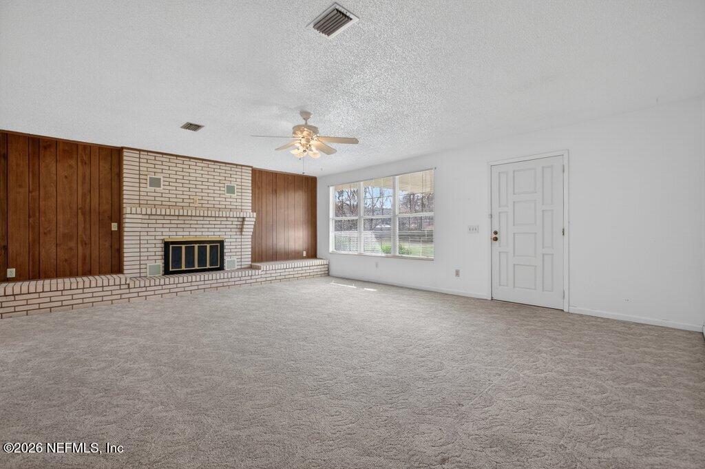 5785 George Hodges Road Macclenny, FL 32063 - Photo 14 of 55 a view of an empty room with a fireplace and a window