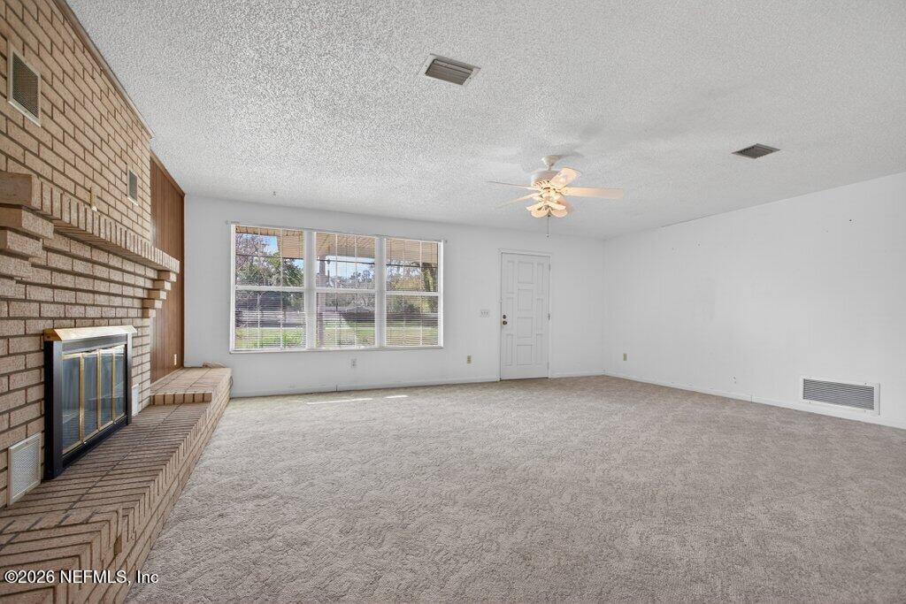 5785 George Hodges Road Macclenny, FL 32063 - Photo 16 of 55 a view of an empty room with a fireplace and a window