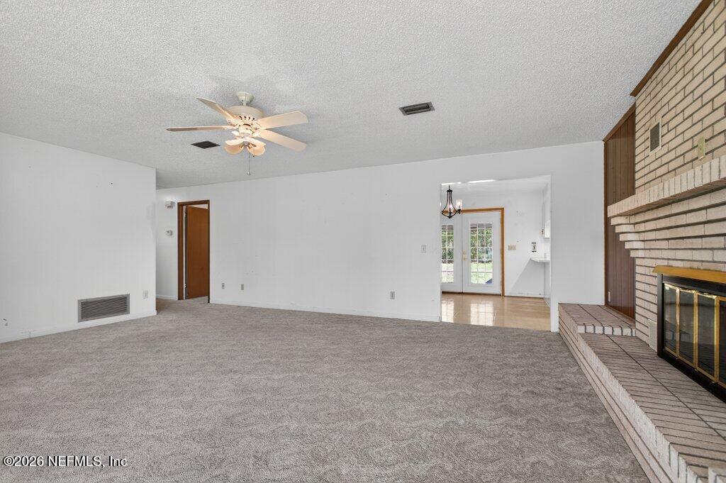 5785 George Hodges Road Macclenny, FL 32063 - Photo 17 of 55 an empty room with fireplace and a ceiling fan