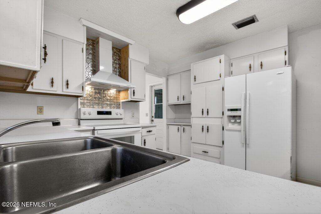 5785 George Hodges Road Macclenny, FL 32063 - Photo 25 of 55 a kitchen with white cabinets and white appliances