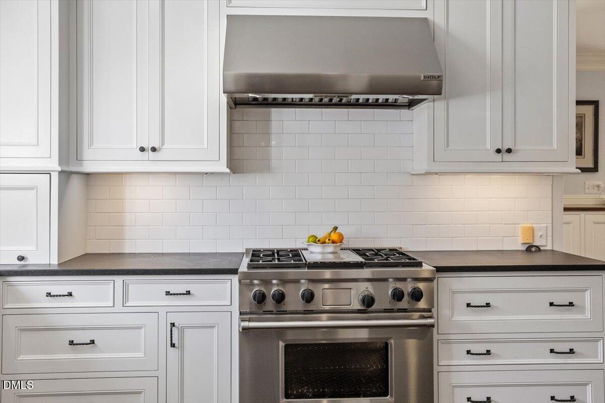2416 East Lake Drive Raleigh, NC 27609 - Photo 12 of 42 a kitchen with granite countertop white cabinets and stainless steel appliances