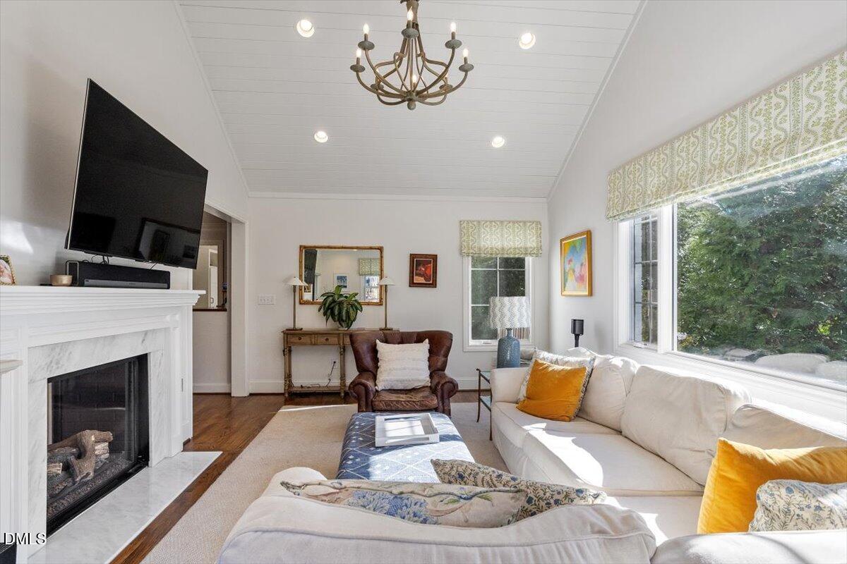2416 East Lake Drive Raleigh, NC 27609 - Photo 16 of 42 a living room with furniture a flat screen tv and a fireplace