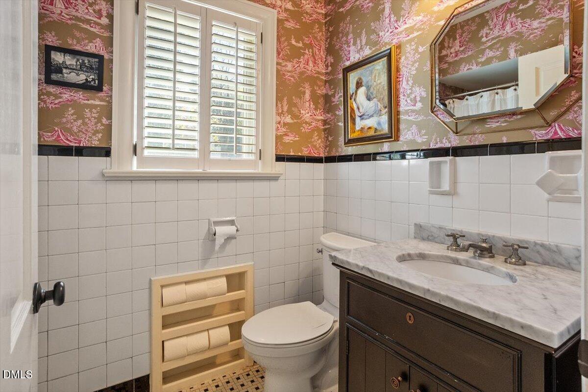 2416 East Lake Drive Raleigh, NC 27609 - Photo 19 of 42 a bathroom with a granite countertop toilet sink and mirror