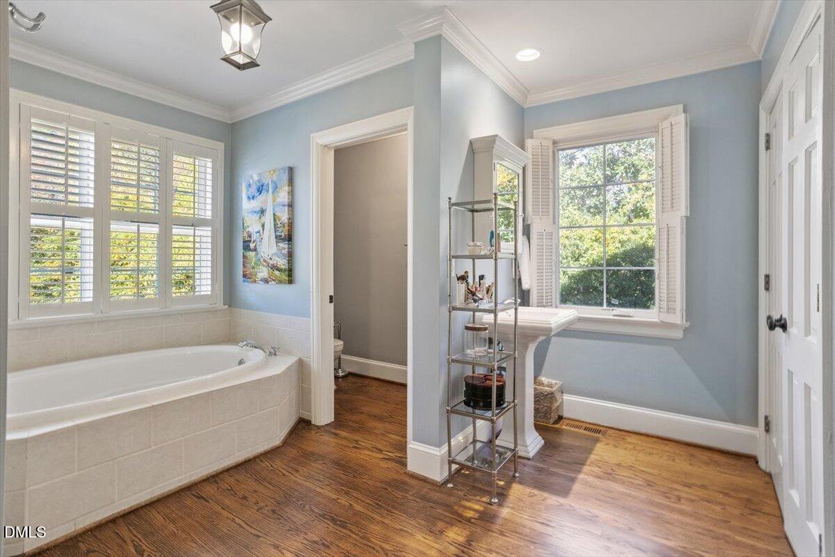 2416 East Lake Drive Raleigh, NC 27609 - Photo 25 of 42 a bathroom with a tub a sink and a window