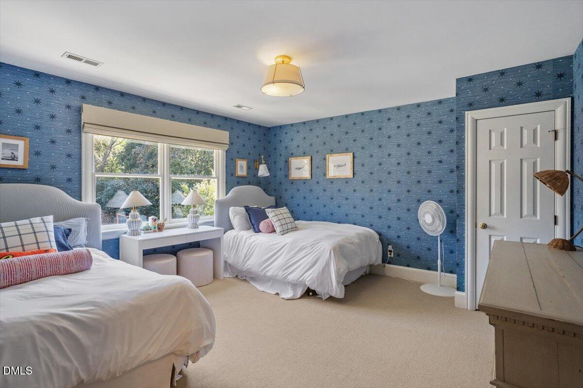 2416 East Lake Drive Raleigh, NC 27609 - Photo 28 of 42 a bedroom with two beds and a chandelier