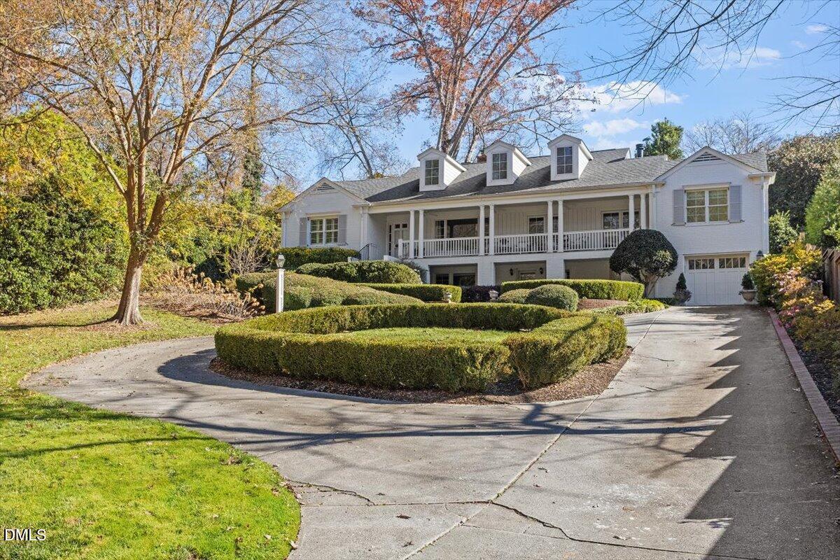 2416 East Lake Drive Raleigh, NC 27609 - Photo 3 of 42 a front view of a house with a garden and trees