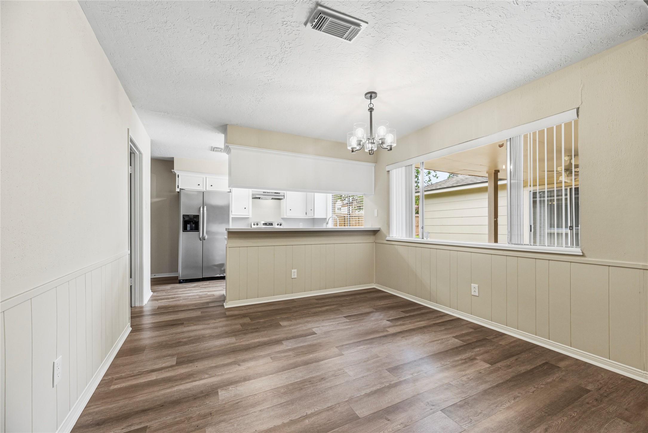 6931 Sandy Knolls Drive Spring, TX 77379 - Photo 2 of 21 Kitchen opens up to a bright breakfast area with wood-style flooring, a modern chandelier, and large window is great for entertaining.
**6931 Sandy Knolls Dr., Spring, TX 77379**