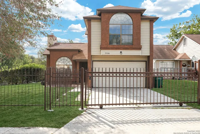 a view of a house with a small yard and wooden fence