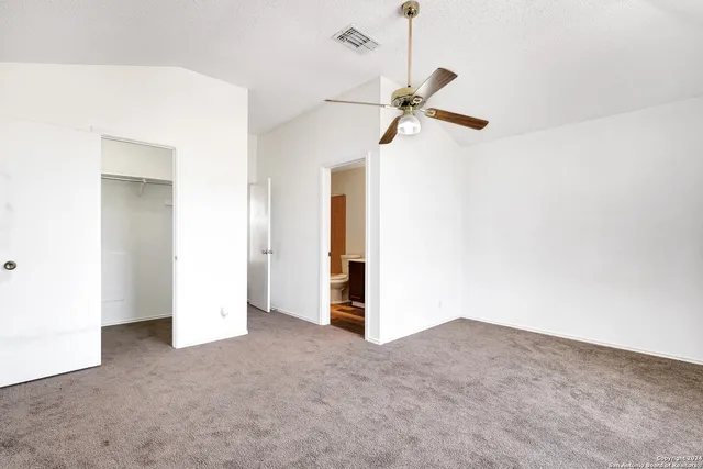 an empty room with windows and ceiling fan