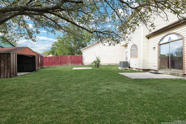 a backyard of a house with table and chairs