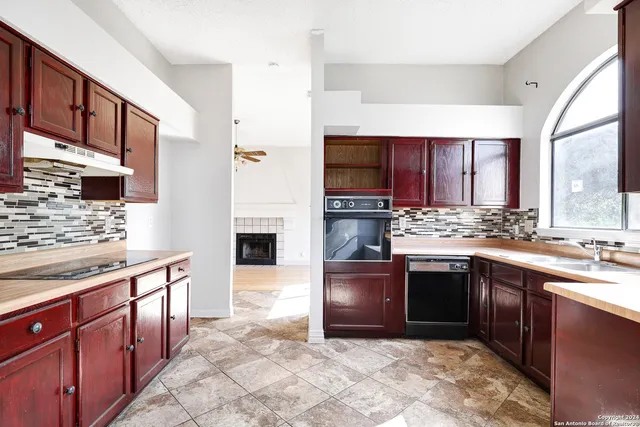 a kitchen with stainless steel appliances granite countertop a stove sink and cabinets