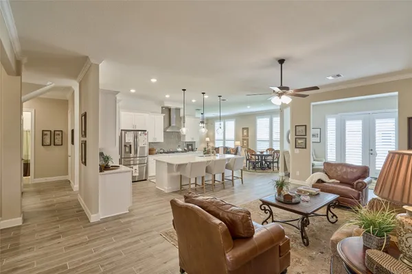 a kitchen with stainless steel appliances kitchen island a table chairs sink and cabinets