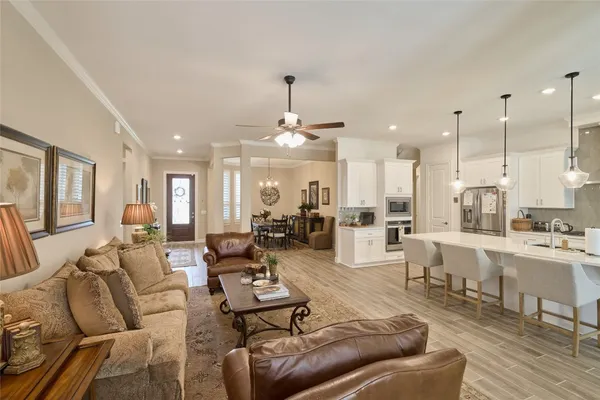 a large living room with stainless steel appliances kitchen island granite countertop a large kitchen a sink and a wooden floors