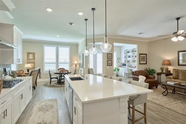a living room with furniture kitchen view and a large window