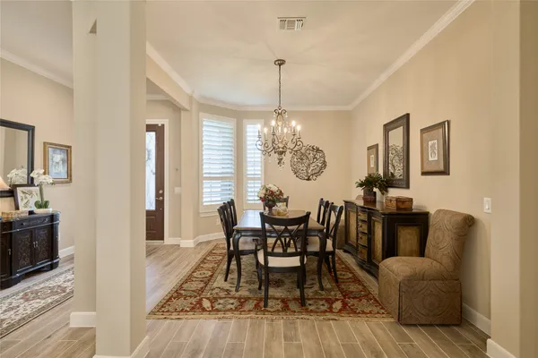 a living room with lots of furniture kitchen view and a wooden floor