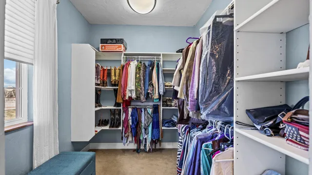 a view of walk in closet with clothes