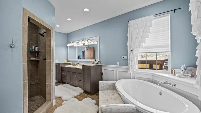 a bathroom with a bathtub sink and mirror