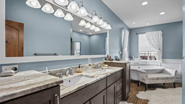 a bathroom with a granite countertop sink a large mirror and a toilet