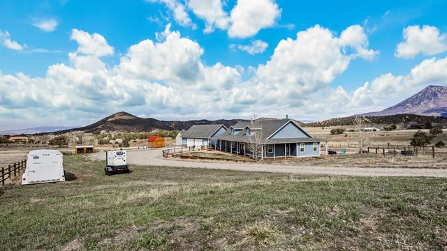 a view of a house with a big yard and large trees