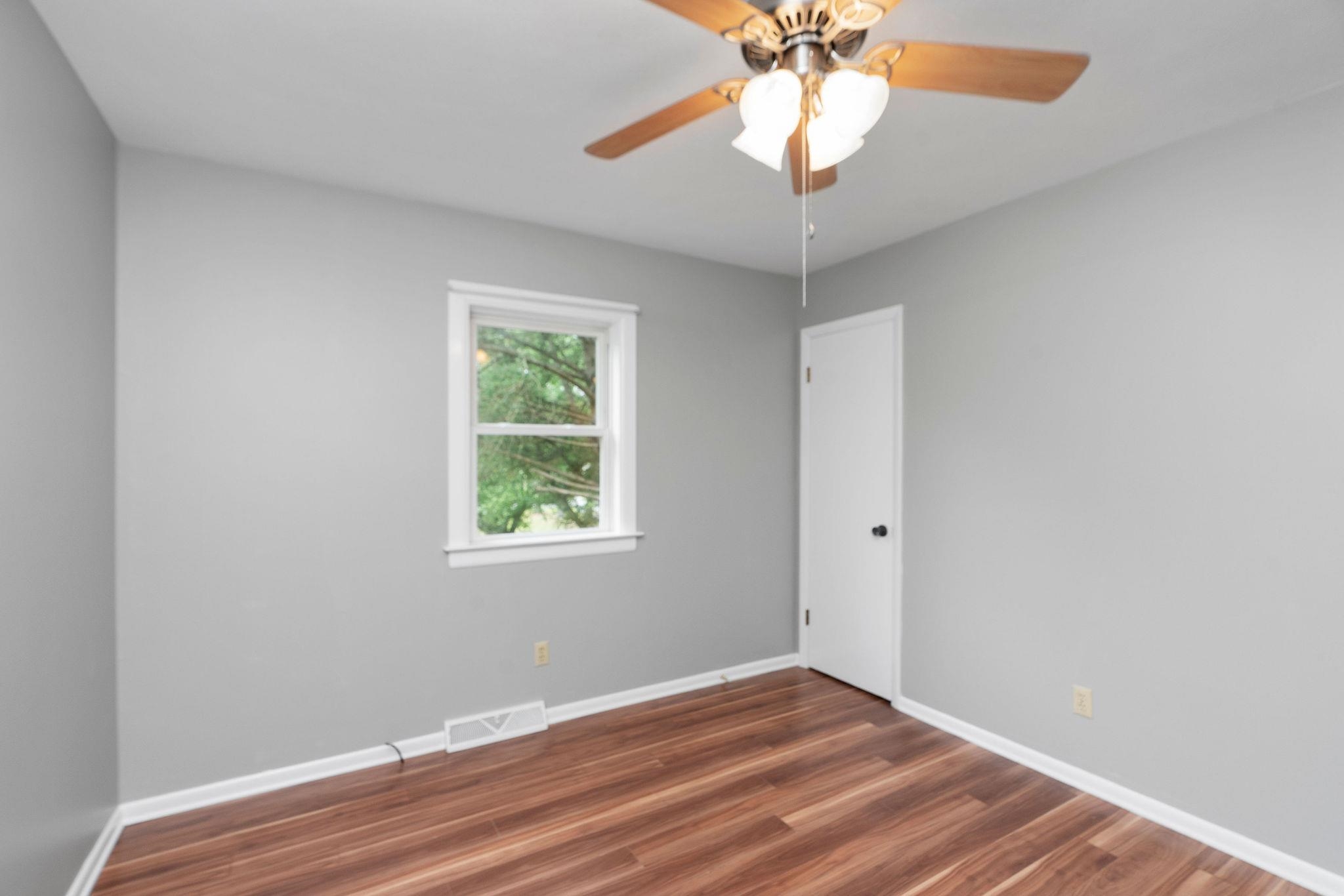 5264 Cold Springs Road Raphine, VA 24472 - Photo 30 of 57 an empty room with wooden floor chandelier fan and window