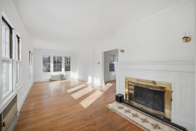 an empty room with windows and fireplace