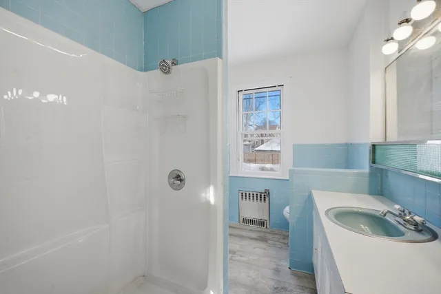 a bathroom with a sink a toilet and shower