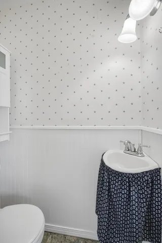 a bathroom with a sink a toilet and a mirror