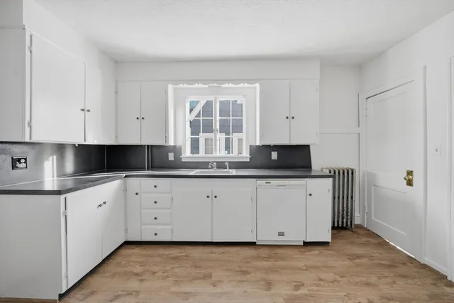 a kitchen with granite countertop white cabinets and sink